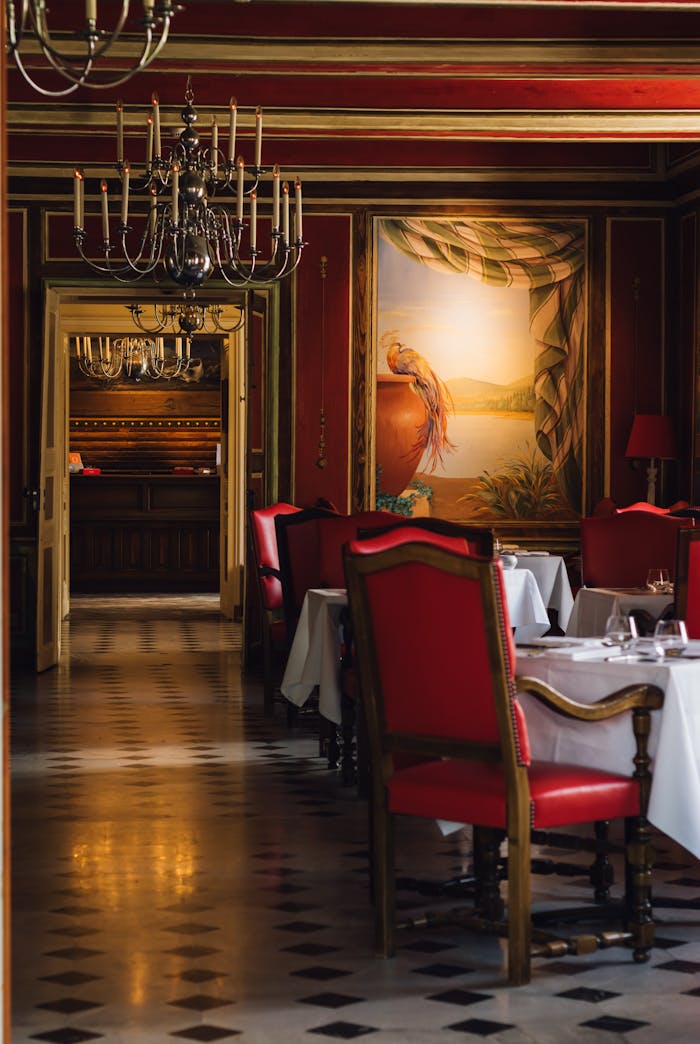 Luxurious dining room in a French restaurant with red chairs and chandeliers in Vonnas.
